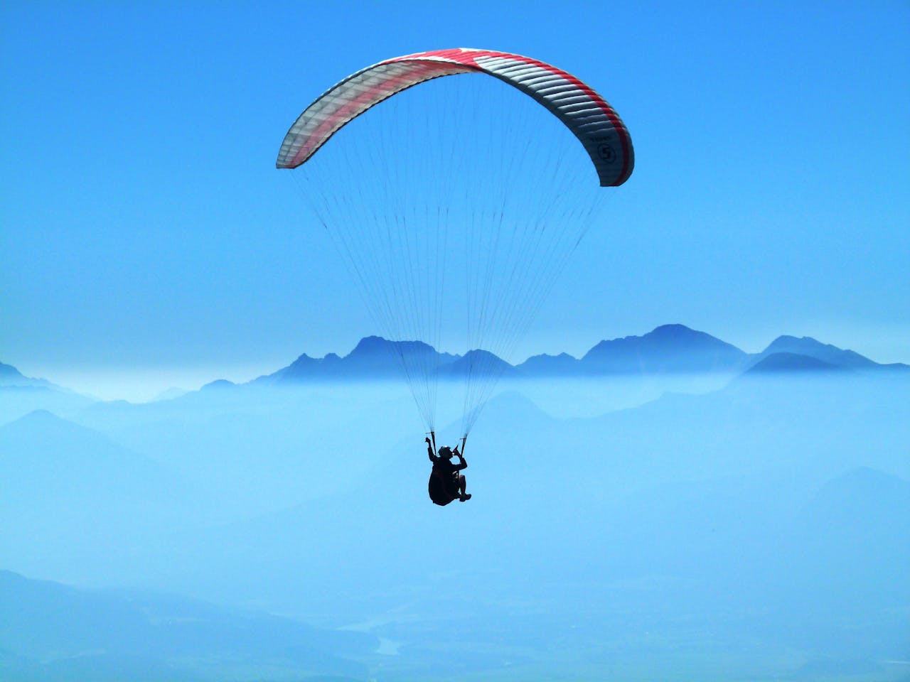 Experience the thrill of paragliding over scenic mountain landscapes.